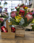 Floral arrangement with cans of Carlton Draught beer on a white background