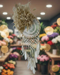 Decorative dreamcatcher with feathers and floral elements on a white background