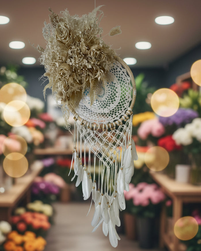 Decorative dreamcatcher with feathers and floral elements on a white background