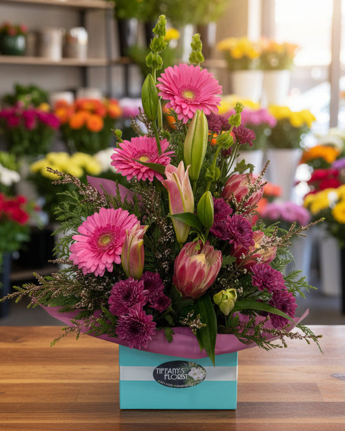 Bouquet of flowers with pink and purple flowers in a box on a white background