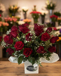 Bouquet of red roses with baby's breath in a box, branded 'Tiffany's Florist'.