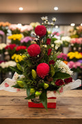 Bouquet of red and white flowers with green leaves on a white background