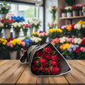 Bouquet of red roses wrapped in black paper on a white background