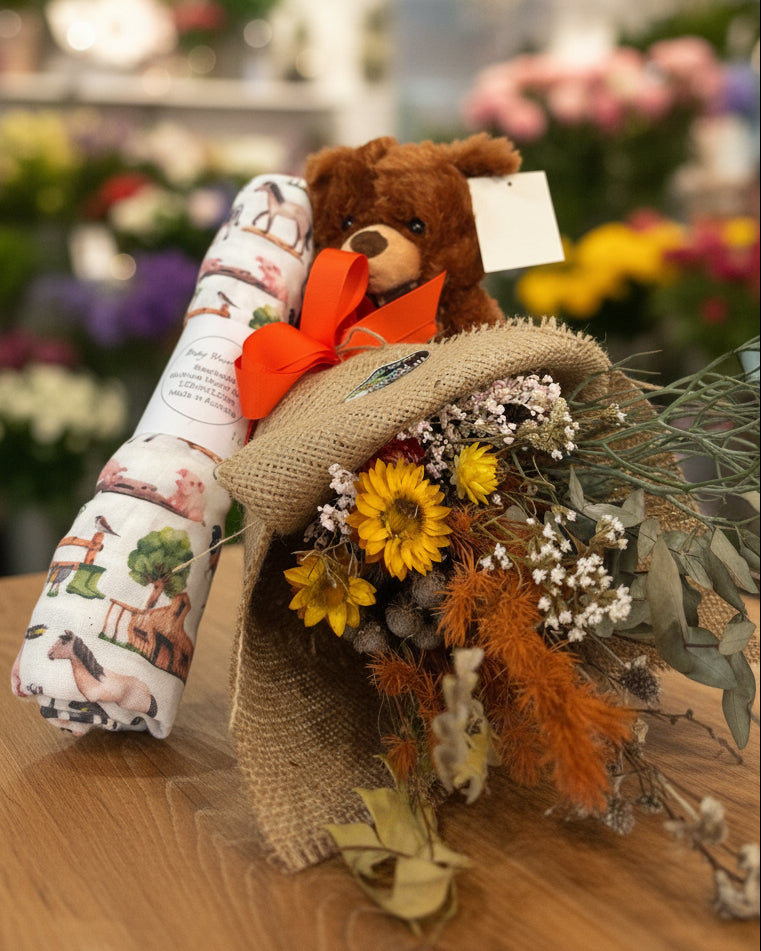 Teddy bear with a bouquet of flowers and a scroll on a white background