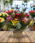 Floral arrangement with a can of Carlton Light beer surrounded by flowers on a white background