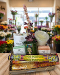 Gifting basket with candles, incense, and decorative items on a white background