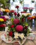 Floral arrangement with red and pink flowers on a white background