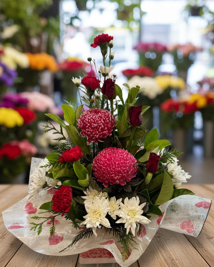 Floral arrangement with red and pink flowers on a white background
